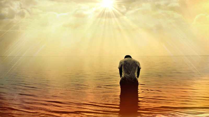 Frau sitzte auf einem Steg am See